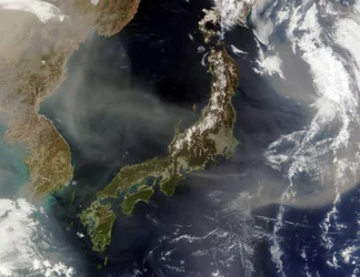 Satellitenansicht von Japan mit schneebedeckten Bergen, Frühlingsbegrünung auf niedrigeren Ebenen. Staub aus dem chinesischen Festland weht über das Japanische Meer und hinaus in den Pazifik. Wissenschaft Geologie